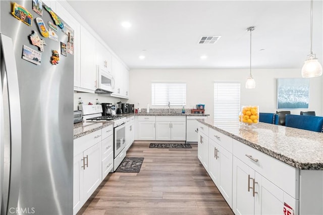 2044 E Lingard St, Lancaster, CA 93535 - kitchen with white appliances, light wood-style flooring, white cabinets, a center island, and recessed lighting