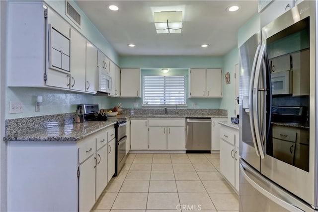 27930 Lexington Ct, Menifee, CA 92586 - kitchen with stainless steel appliances, a sink, light tile patterned flooring, white cabinetry, and light stone counters
