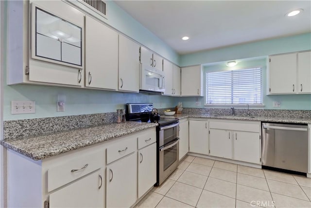 27930 Lexington Ct, Menifee, CA 92586 - kitchen featuring appliances with stainless steel finishes, a sink, light tile patterned floors, white cabinets, and recessed lighting