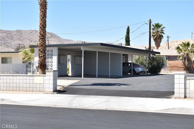 73636 Cactus Dr Unit 29, Palms, CA 92277 - view of front of home featuring a mountain view, fence, and covered parking