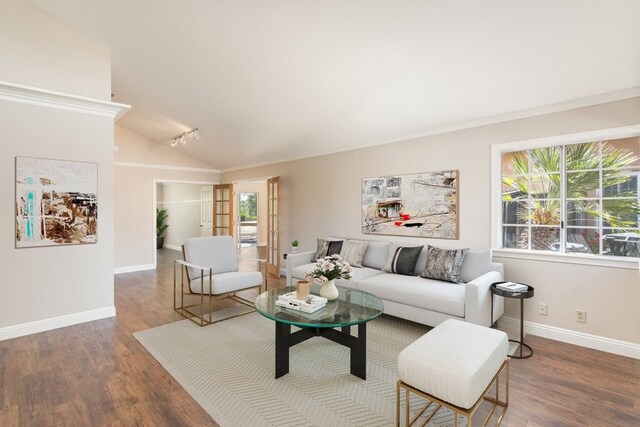 living area with plenty of natural light, wood finished floors, vaulted ceiling, and baseboards