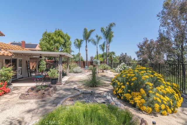 fenced backyard featuring a ceiling fan and a patio area