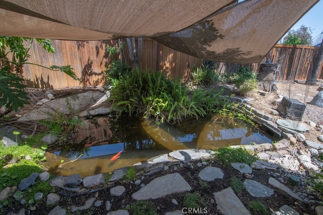 view of yard with a garden pond and fence