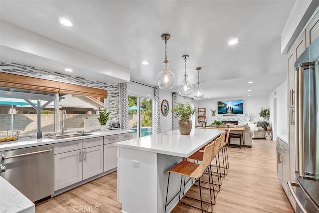 1836 Macinnes Pl, Placentia, CA 92870 - kitchen featuring appliances with stainless steel finishes, a sink, open floor plan, tasteful backsplash, and light countertops
