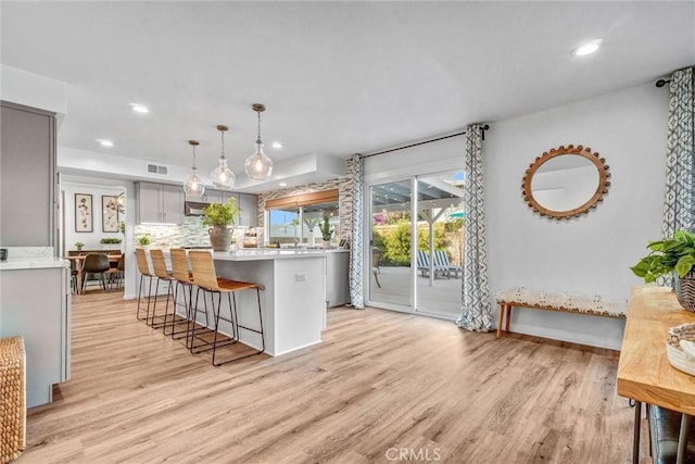 1836 Macinnes Pl, Placentia, CA 92870 - kitchen with light countertops, light wood finished floors, a breakfast bar area, recessed lighting, and backsplash