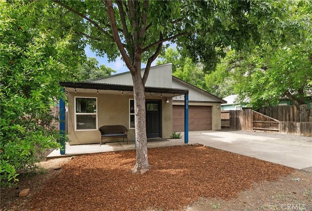 1274 Humboldt Ave, Chico, CA 95928 - view of front of house with driveway, fence, stucco siding, a garage, and metal roof