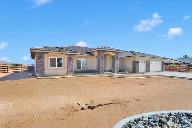 21192 Zuni Rd, Apple Valley, CA 92307 - view of front of property with a tile roof, an attached garage, stucco siding, driveway, and central air condition unit