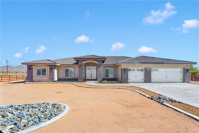 21192 Zuni Rd, Apple Valley, CA 92307 - mediterranean / spanish house with stucco siding, a tile roof, concrete driveway, a garage, and stone siding