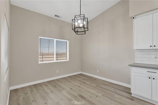 21192 Zuni Rd, Apple Valley, CA 92307 - unfurnished dining area with a chandelier, light wood-style flooring, and baseboards