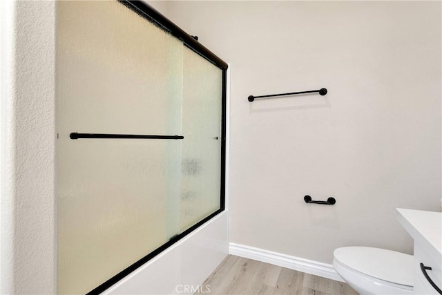 21192 Zuni Rd, Apple Valley, CA 92307 - full bathroom with wood finished floors, enclosed tub / shower combo, toilet, and baseboards