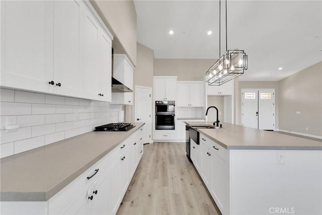 21192 Zuni Rd, Apple Valley, CA 92307 - kitchen with black gas stovetop, a sink, light wood-style flooring, backsplash, and white cabinets