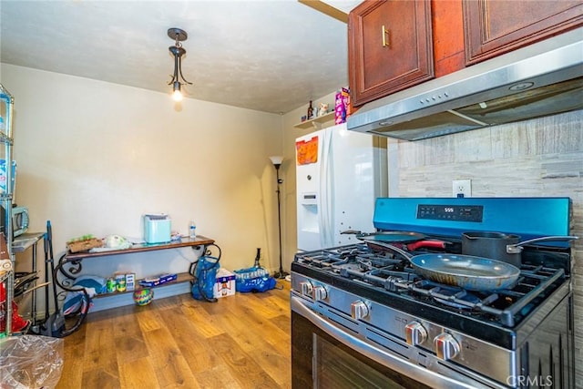 6916 36th St, Jurupa Valley, CA 92509 - kitchen featuring stainless steel gas range, under cabinet range hood, wood finished floors, and white refrigerator with ice dispenser
