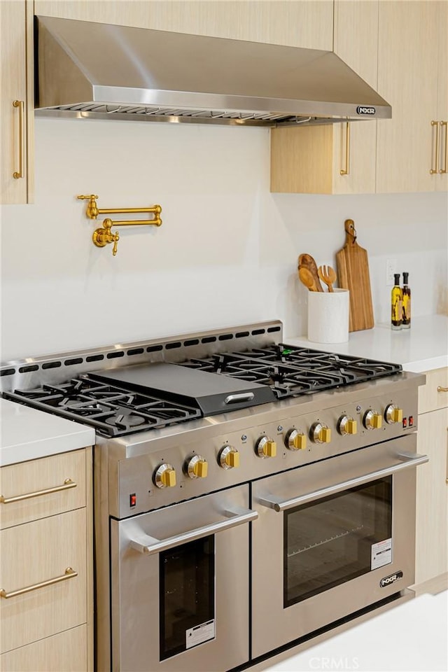 80 Seton Rd, Irvine, CA 92612 - kitchen featuring light brown cabinetry, wall chimney range hood, range with two ovens, and light countertops