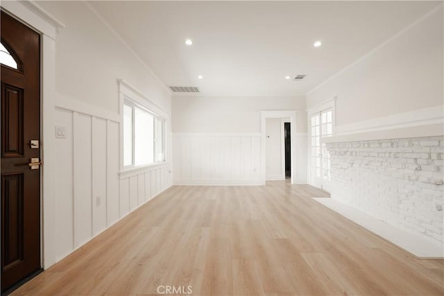 247 S Benton Way, Los Angeles, CA 90057 - unfurnished living room with light wood-style floors, wainscoting, plenty of natural light, a decorative wall, and recessed lighting