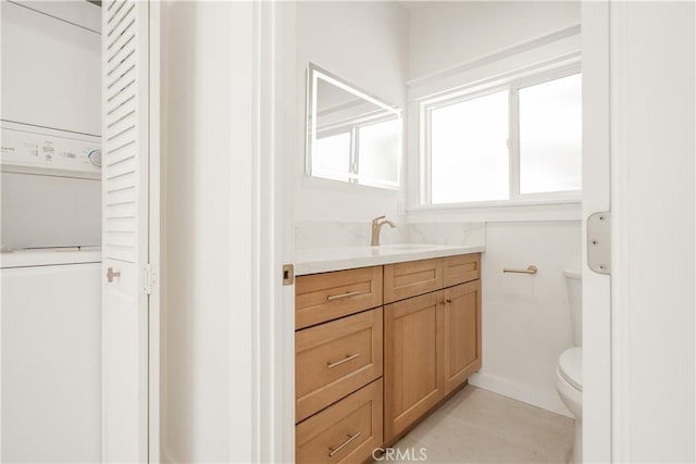 247 S Benton Way, Los Angeles, CA 90057 - bathroom featuring stacked washer and clothes dryer, toilet, vanity, and tile patterned flooring