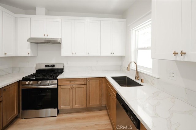 247 S Benton Way, Los Angeles, CA 90057 - kitchen featuring stainless steel appliances, a sink, under cabinet range hood, light stone counters, and light wood-style floors
