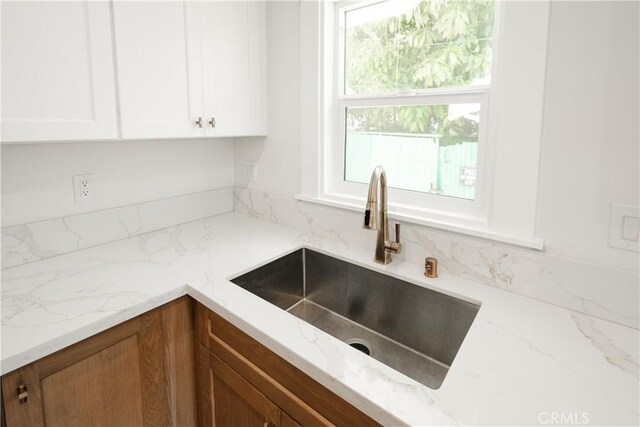247 S Benton Way, Los Angeles, CA 90057 - kitchen with a sink, light stone counters, and white cabinetry