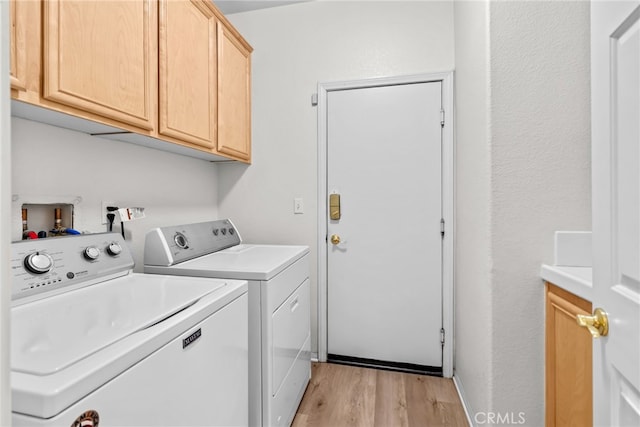 9011 Honeysuckle Ave, Hesperia, CA 92344 - washroom featuring cabinet space, washing machine and dryer, and light wood-style floors