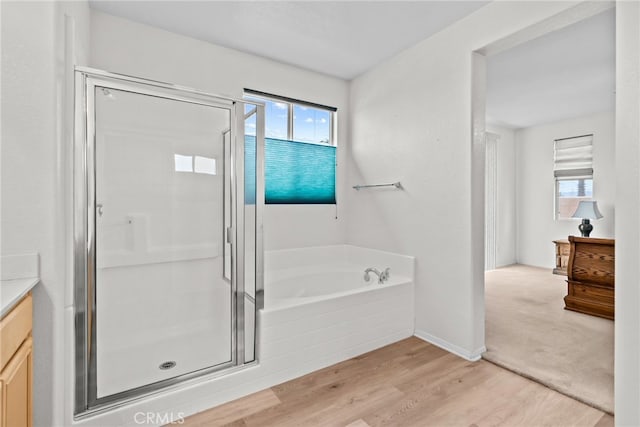 9011 Honeysuckle Ave, Hesperia, CA 92344 - full bath with vanity, a stall shower, a garden tub, and wood finished floors