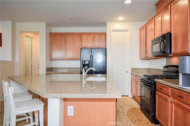 2750E Oak Hill Dr Unit 16, Ontario, CA 91761 - kitchen featuring black appliances, a sink, a breakfast bar, light stone counters, and recessed lighting