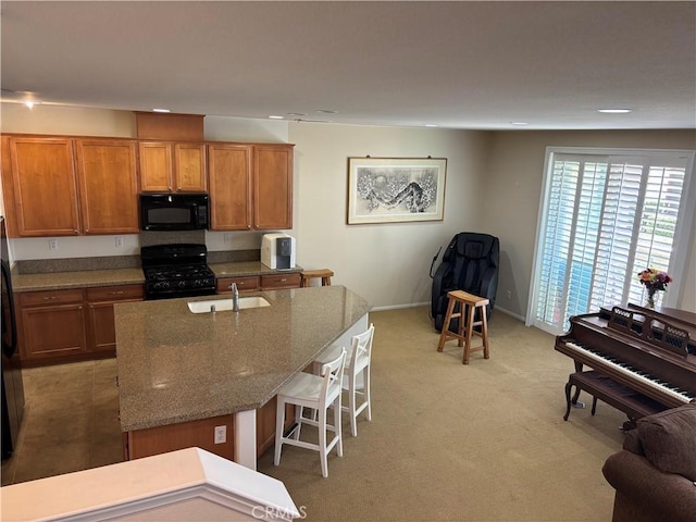 2750E Oak Hill Dr Unit 16, Ontario, CA 91761 - kitchen with black appliances, a sink, brown cabinets, stone countertops, and a breakfast bar area