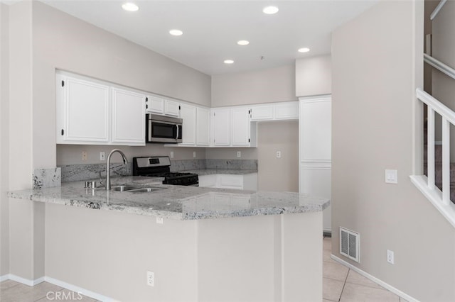 170 Valley View Ter, Mission Viejo, CA 92692 - kitchen with stainless steel appliances, a sink, a peninsula, light stone countertops, and white cabinetry