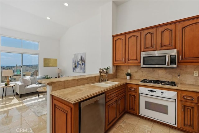 123 Costa Brava, Laguna Niguel, CA 92677 - kitchen with stainless steel appliances, a peninsula, light countertops, high vaulted ceiling, and a sink