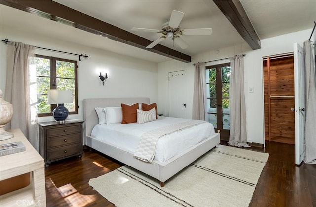 bedroom with french doors, beamed ceiling, dark wood finished floors, multiple windows, and a ceiling fan