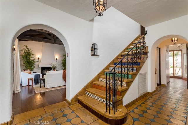 staircase featuring arched walkways and baseboards