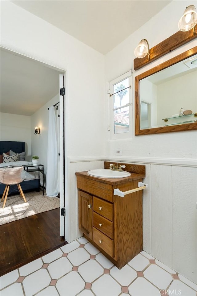 bathroom featuring a wainscoted wall, tile patterned floors, and vanity