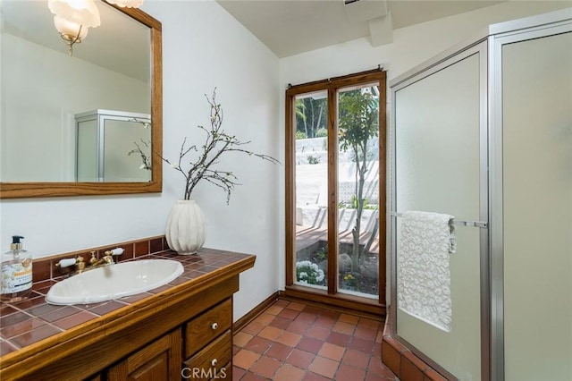 bathroom featuring tile patterned floors, vanity, and a shower with door