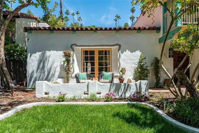 rear view of property featuring stucco siding and a tiled roof