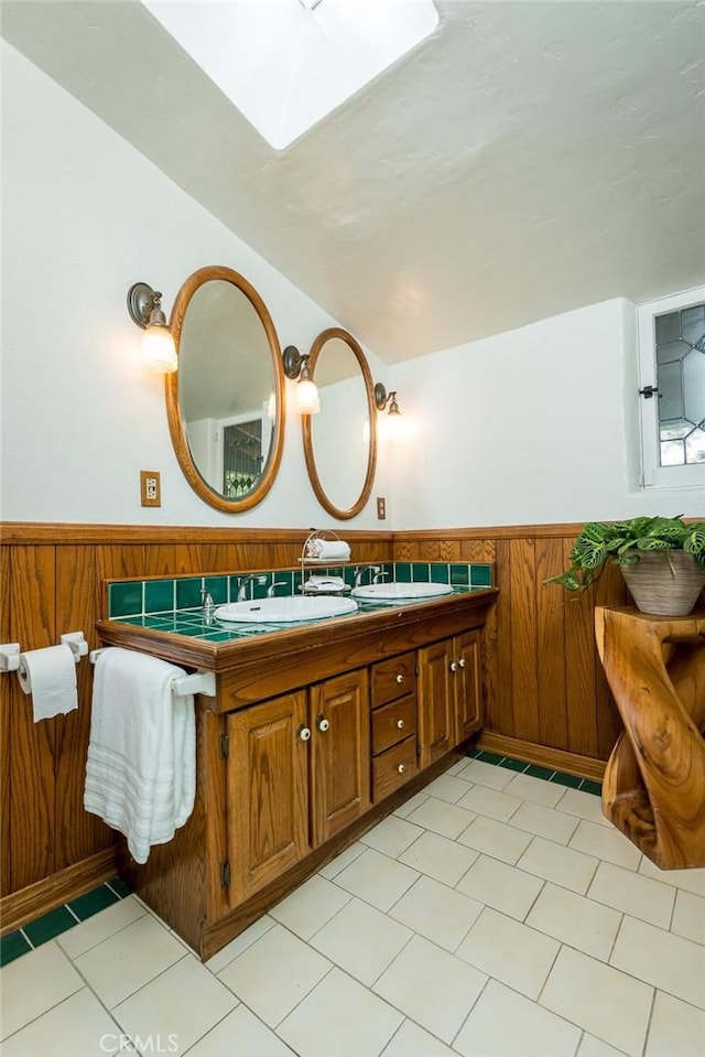 bathroom with wainscoting, vanity, and wood walls