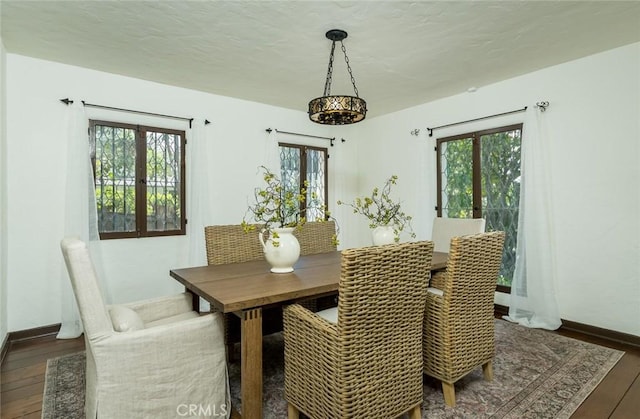 dining area with wood-type flooring, baseboards, and french doors