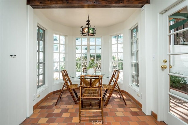 sunroom featuring a chandelier, baseboards, and french doors