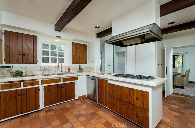 kitchen with a sink, dishwasher, beamed ceiling, a peninsula, and brown cabinets