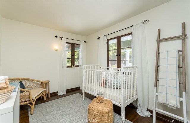 bedroom featuring french doors, wood finished floors, and baseboards