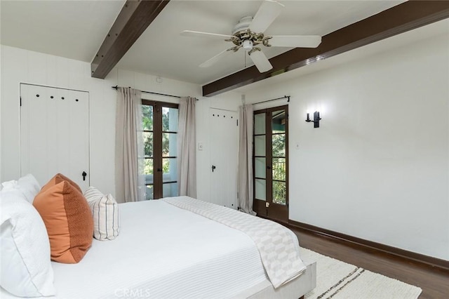 bedroom with beamed ceiling, wood finished floors, french doors, baseboards, and a ceiling fan