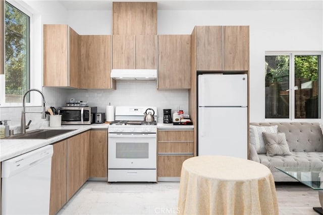 14027 Wyandotte St, Van Nuys, CA 91405 - kitchen featuring white appliances, under cabinet range hood, a sink, and plenty of natural light