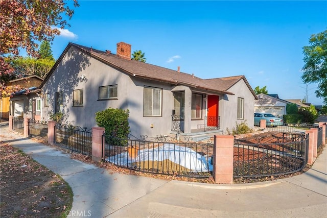 14027 Wyandotte St, Van Nuys, CA 91405 - view of front of property with a chimney, a fenced front yard, and stucco siding