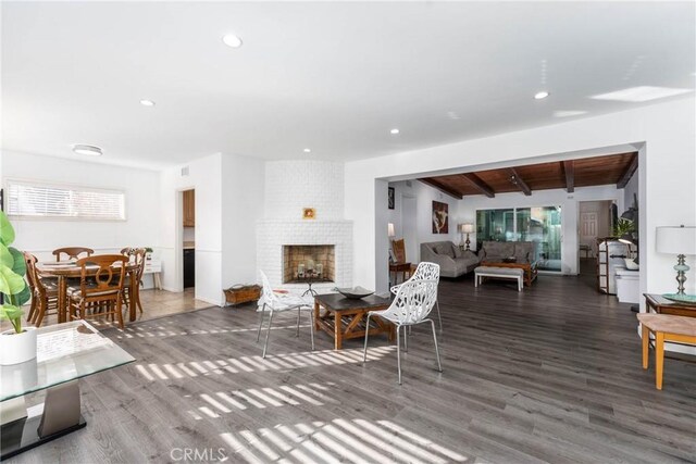 14027 Wyandotte St, Van Nuys, CA 91405 - living area featuring beam ceiling, wood finished floors, recessed lighting, and a brick fireplace