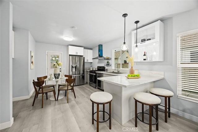 2461 Saint Pierre Ave, Altadena, CA 91001 - kitchen featuring appliances with stainless steel finishes, wall chimney exhaust hood, a kitchen bar, and a peninsula