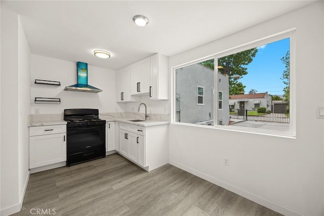2461 Saint Pierre Ave, Altadena, CA 91001 - kitchen with wall chimney range hood, black gas range, a sink, and light wood-type flooring