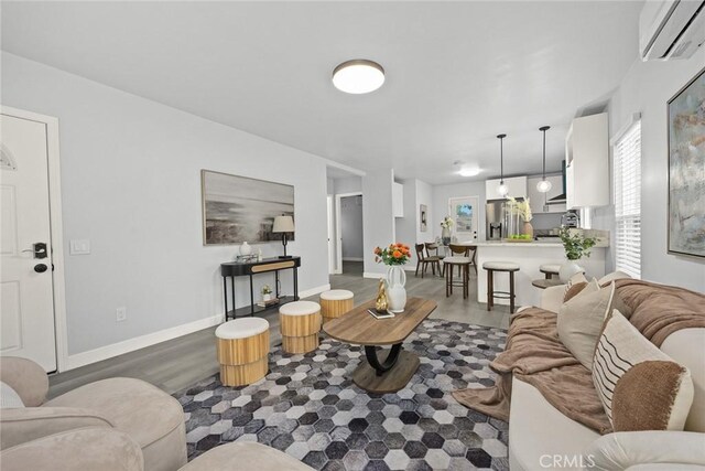2461 Saint Pierre Ave, Altadena, CA 91001 - living room featuring wood finished floors, a wall mounted air conditioner, and baseboards