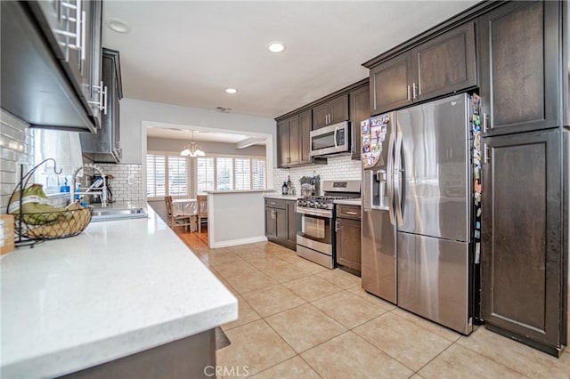 824 S Fenimore Ave, Covina, CA 91723 - kitchen featuring stainless steel appliances, a sink, dark brown cabinetry, light countertops, and backsplash