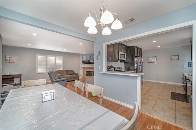 824 S Fenimore Ave, Covina, CA 91723 - dining area featuring a chandelier, recessed lighting, a fireplace, baseboards, and light tile patterned floors