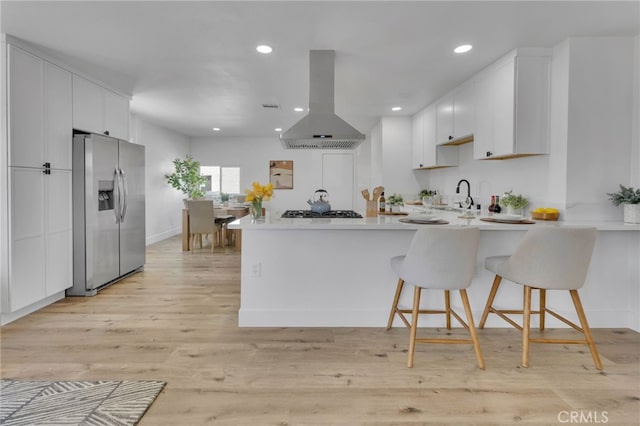 8332 Cherimoya Ave, Fontana, CA 92335 - kitchen featuring stainless steel refrigerator with ice dispenser, island exhaust hood, a peninsula, light countertops, and recessed lighting