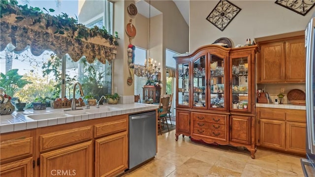 1551 Dominguez Ranch Rd, Corona, CA 92882 - kitchen featuring stainless steel dishwasher, a high ceiling, tile countertops, and brown cabinetry