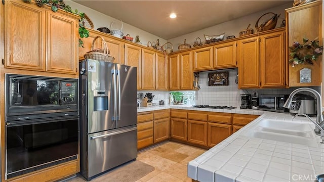1551 Dominguez Ranch Rd, Corona, CA 92882 - kitchen with black appliances, tile counters, tasteful backsplash, brown cabinets, and recessed lighting