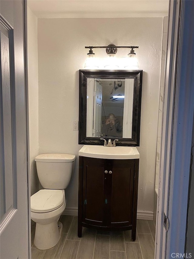 3352 Franklin Ave, Riverside, CA 92507 - bathroom with toilet, vanity, baseboards, and wood finish floors